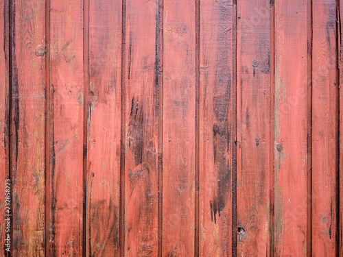 Close-up of old red wooden planks wall texture. Vintage style, rustic wood texture with natural patterns surface as background. Vertical layout. High-quality macro photography.