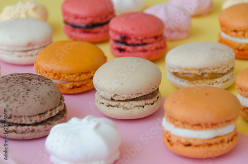 Assortment of macarons and meringues on pink background