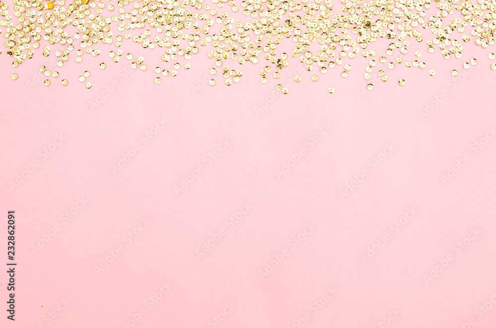 golden sequins on a pink paper background. Decorative accessories for sewing and embroidery. Circle shape shining paillettes. Template for card, invitation. Blank space for text or image.