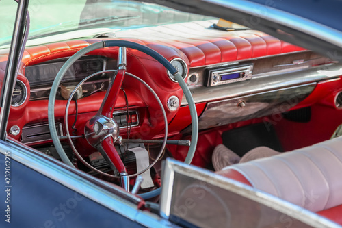Close up interior of a classic retro / vintage american car of 1950s,  steering wheel clock, dashboard, speedometer. The car is Taxi in Havana, Cuba. Outdoor. © Elena