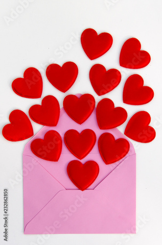 Valentine Day greeting card with heart. Red hearts pours fly out of the opened envelope on white. Love Letter. Flay lay