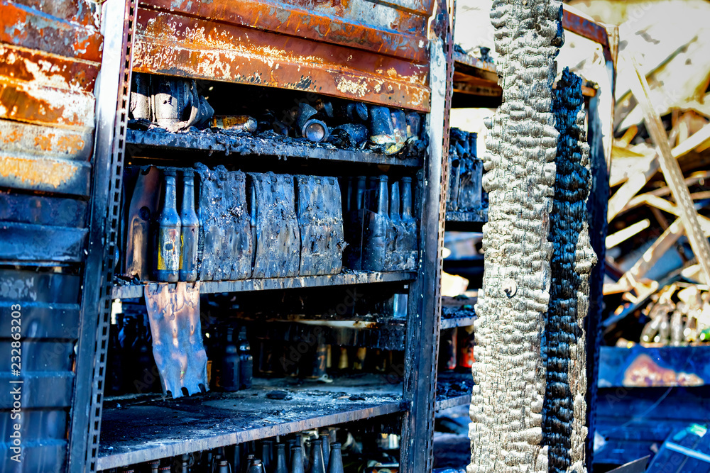 Close up Burned damaged ruins of destroyed bottles on shelf supermarket arson investigation insurance Close up Burned damaged ruins of destroyed bottles on shelf supermarket arson investigation insurance
