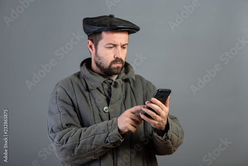 Caucasian man 35 years old with concentrated look at smartphone, studio shot. Idea - village dweller and modern technology photo