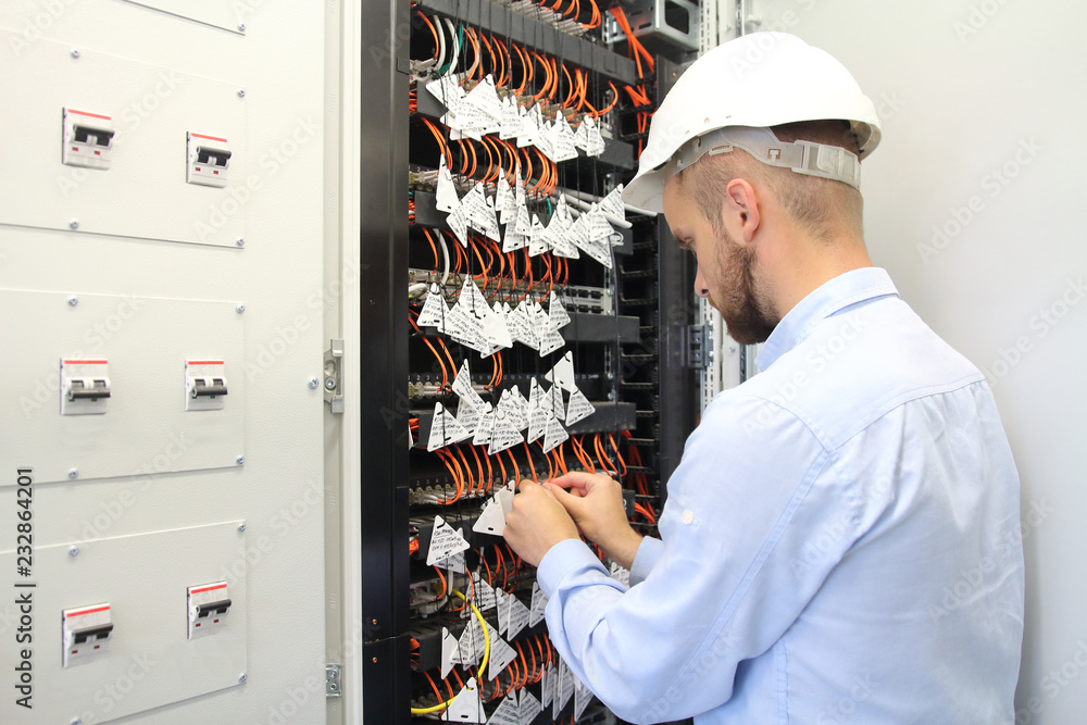 Technician in communications box connecting opto fibers