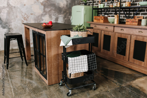 Foto Cozy loft kitchen with dinning table, chairs and metal storage racks on wheels -