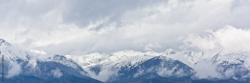 Snow capped mountains with a bank of clouds