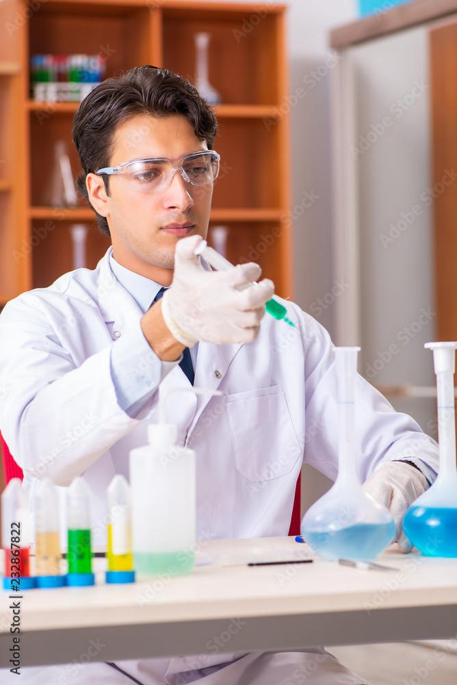 Young handsome biochemist working in the lab Young handsome biochemist working in the lab