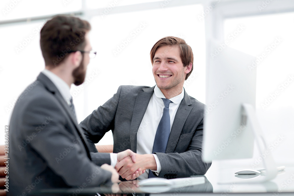 close up. handshake business partners sitting at the Desk close up. handshake business partners sitting at the Desk