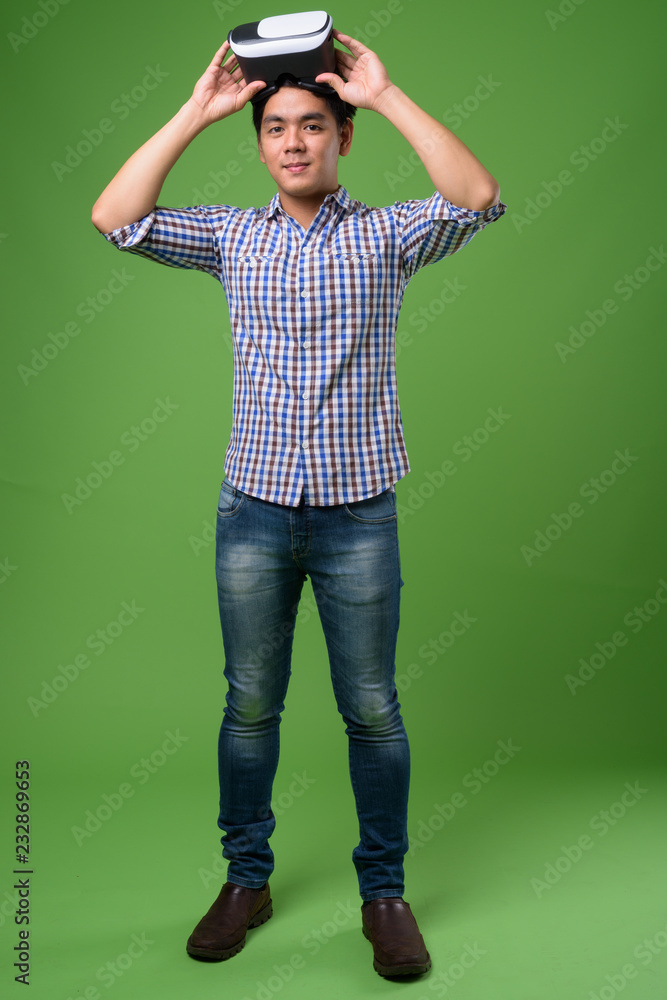 Young handsome Filipino man against green background Young handsome Filipino man against green background
