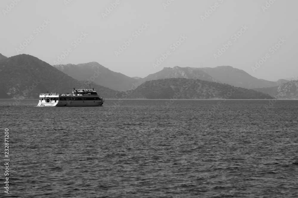 Recreation on the boat near the shore of a mountain. Ship on the water. summer vacation. black and white