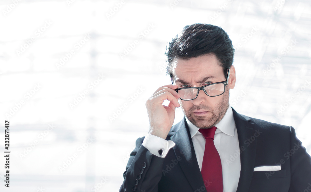 serious businessman looks over his glasses serious businessman looks over his glasses