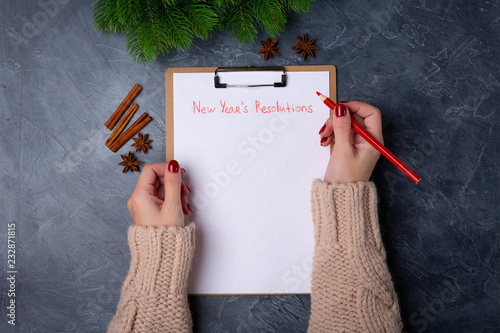 Photos Woman hands ready to write new year's resolutions on blank list on dark background
