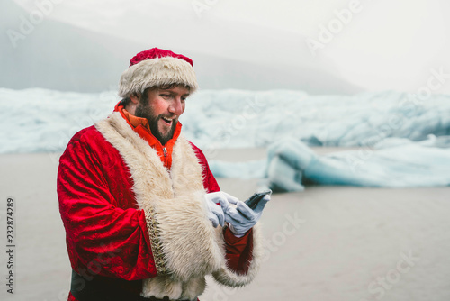 Santa Claus with smartphone in the mountains of Iceland photo