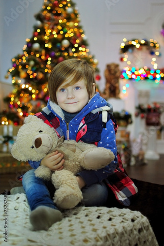Ребенок ждет чуда в Новый год. С новым годом! Счастливого Рождества! Новогодняя елка с рождественскими игрушками. Мальчик с игрушками.
