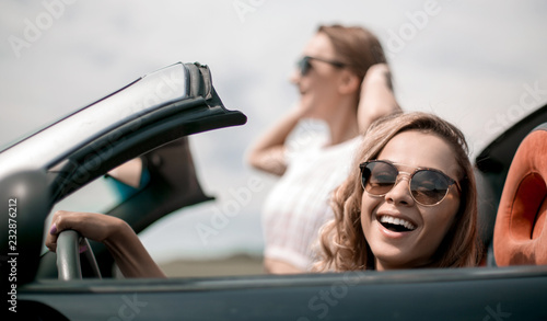 close up.two girlfriends traveling in a convertible car © ASDF