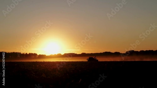 Wallpaper Mural silhouette of combines which harvesting wheat on the field on sunset, long shot Torontodigital.ca