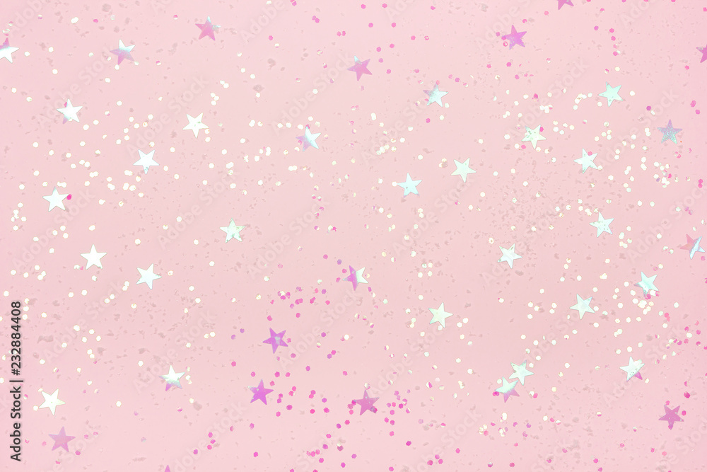 Beautiful pastel pink Christmas background with star shaped confetti. Top view. Copy space for your design.