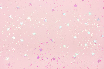 Beautiful pastel pink Christmas background with star shaped confetti. Top view. Copy space for your design.