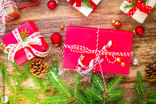 Christmas gift giving concept - christmas presents in red boxes on wooden table, flat lay scene on wood, retro toned