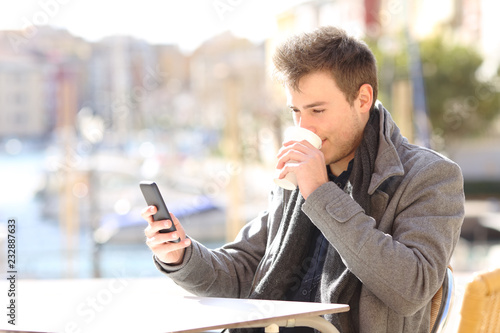 Man drinking and cheking smart phone content