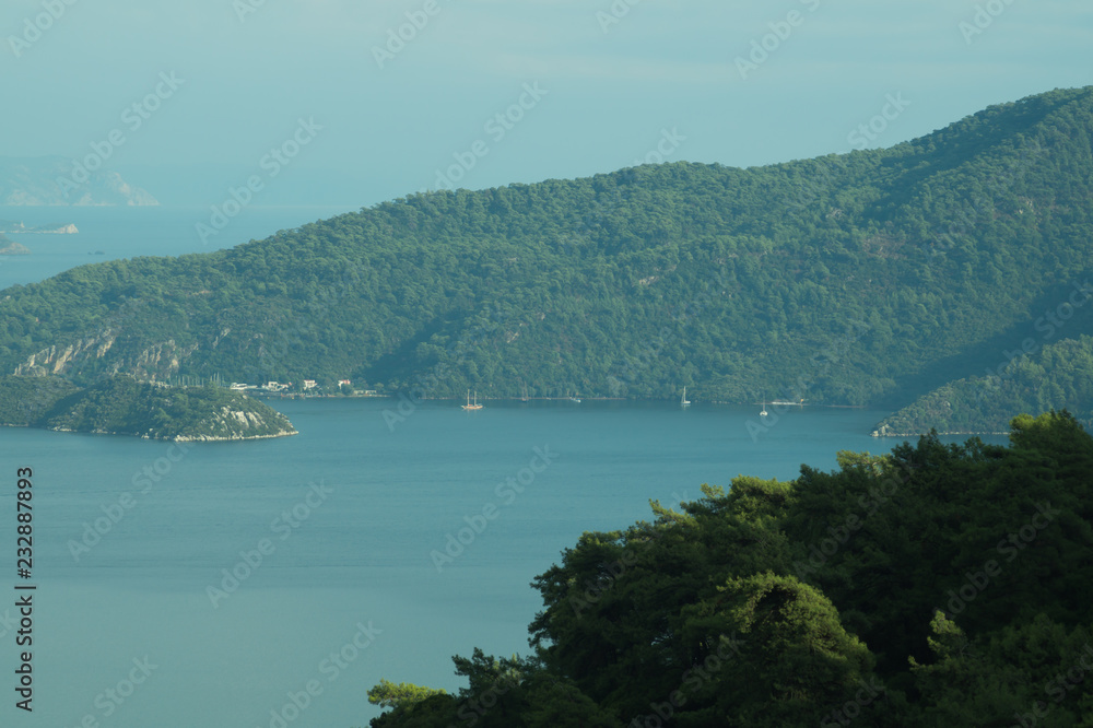 Overgrown mountains on the islands. Seascape background. water surface in a bay