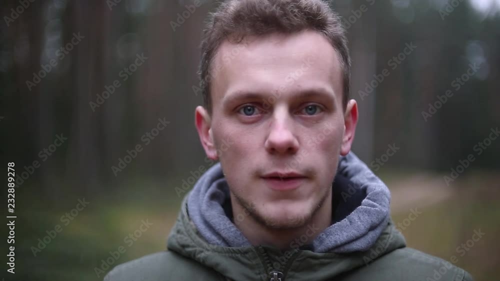 portrait of caucasian man in the forest in cold time. blond hair, blue eyes. portrait of caucasian man in the forest in cold time. blond hair, blue eyes.