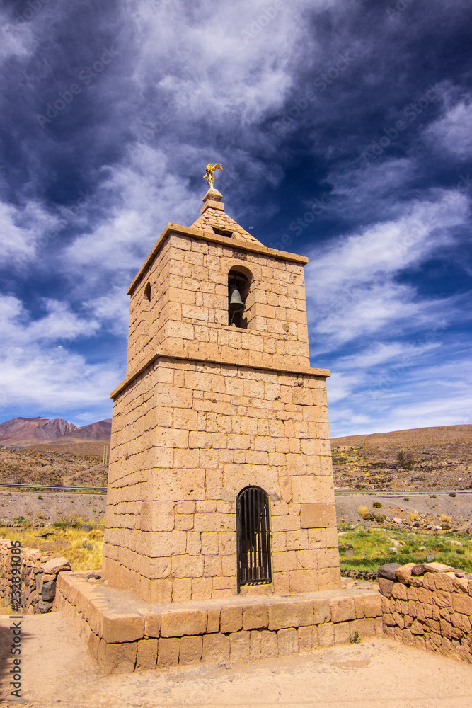 Socaire old stone church tower, historic architecture buildings in the middle of Atacama Desert, tradition and amazing scenery is what we can see in the heart of Andes mountains at the Altiplano
