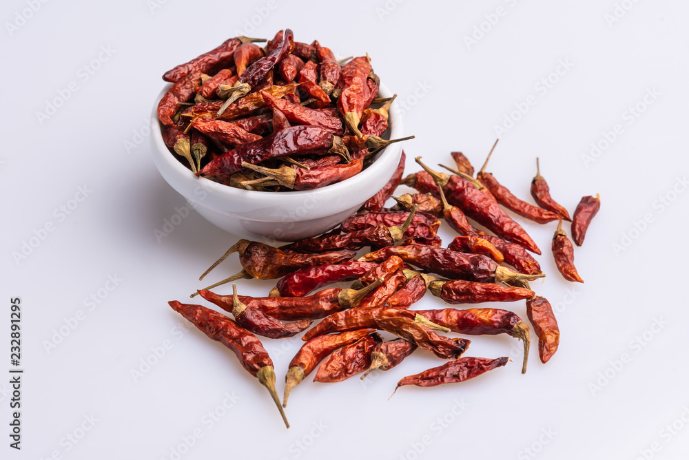 Dried Red hot chilli peppers in white bowl, isolated in white background, Latin term Capsicum frutescens 'Malagueta', dehydrated, angle view, copy space, soft light