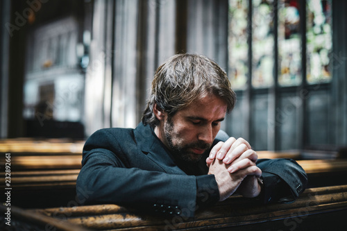 Lonely Christian man praying in the church