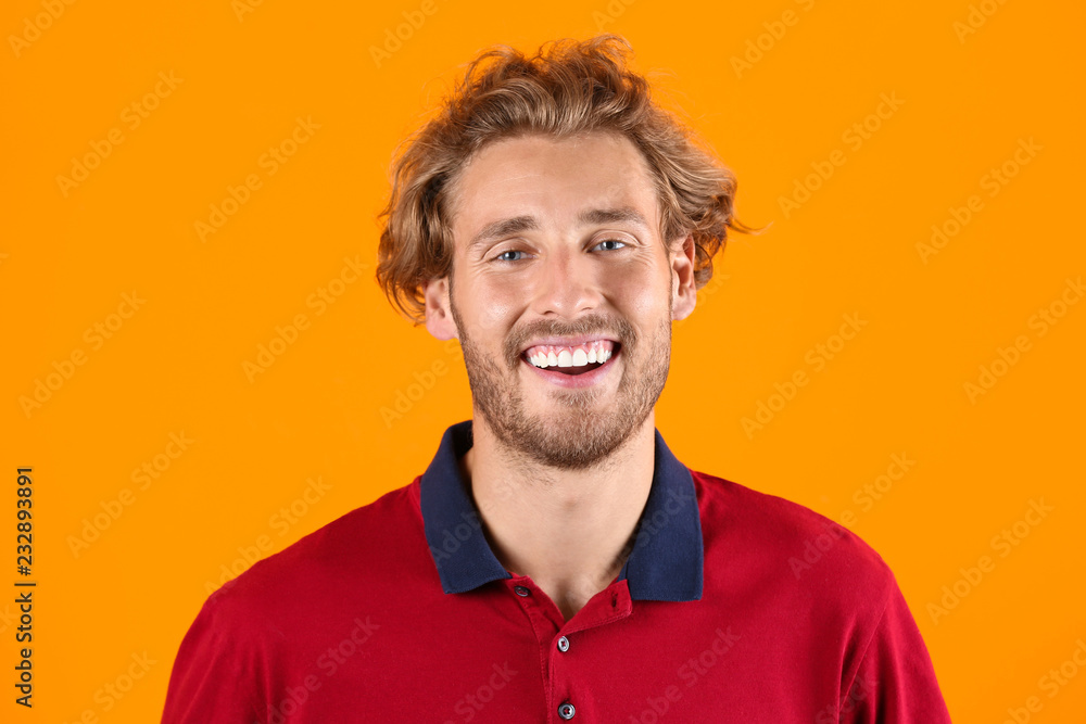 Obraz premium Handsome young man laughing on color background