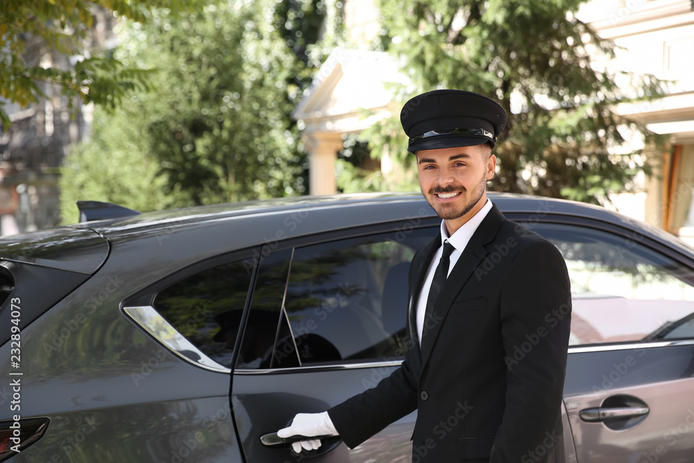 Fototapeta premium Young handsome driver standing near luxury car. Chauffeur service