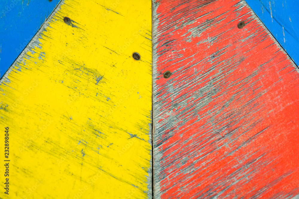 Naklejka premium Yellow, blue and red paint on old wooden background