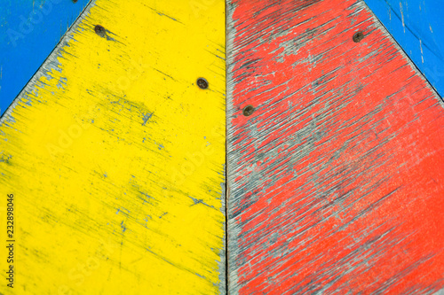 Yellow, blue and red paint on old wooden background