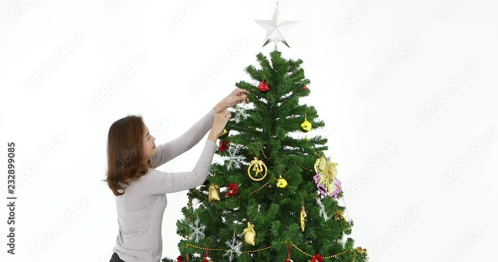 VDO of moving good lookingl Asian woman,decorated Christmas tree by golden, red and silver decorations, the white background , Christmas theme. VDO of moving good lookingl Asian woman,decorated Christmas tree by golden, red and silver decorations, the white background , Christmas theme.