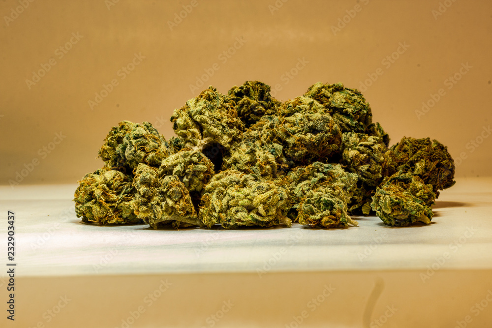 Close up of a pile of green marijuana buds isolated with a white background