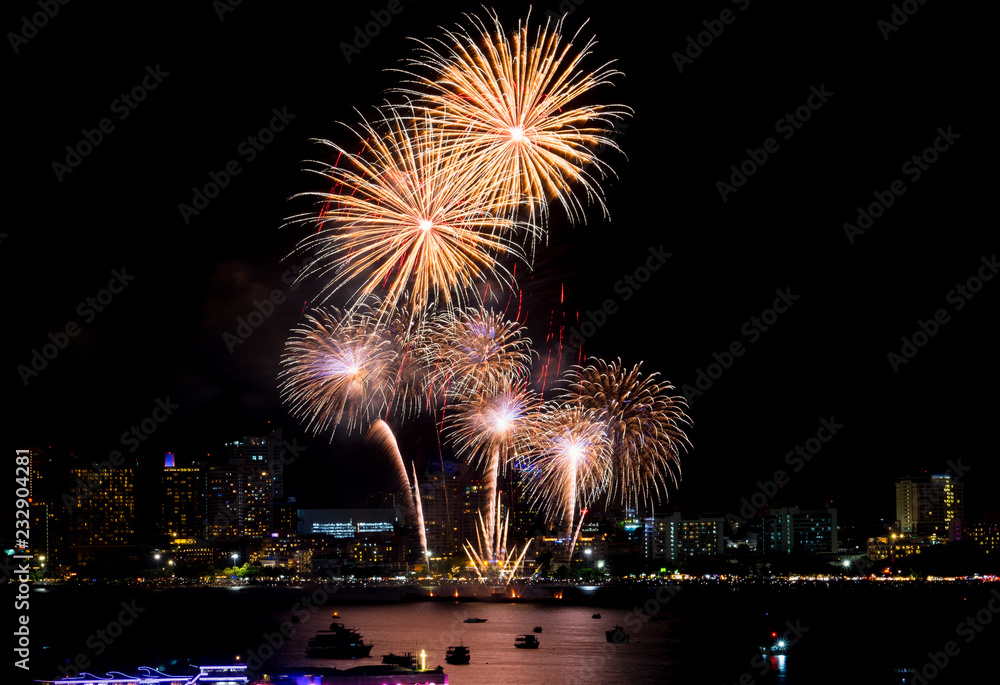 Fireworks explored over cityscape at night in sea port in Pattaya.Holiday festive celebration background.