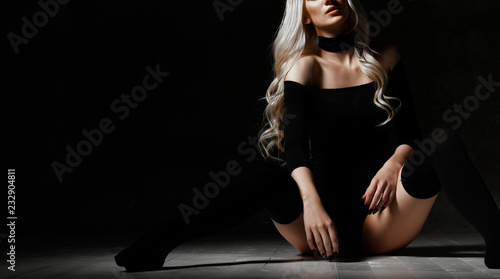 Young sexy blonde fashion woman sitting on floor in black body cloth and choker 