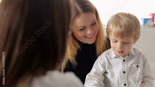 Beautiful young mother and her little son at the pediatrician. Portrait of a young mother and a little boy in a children's hospital. photo