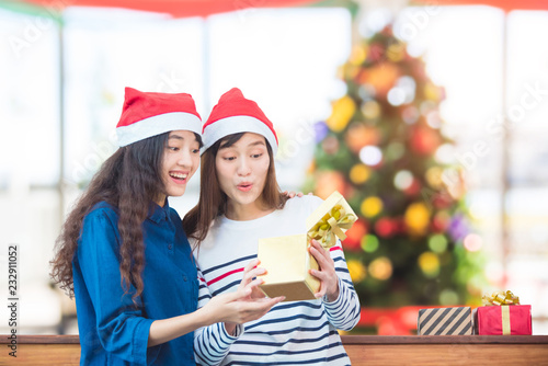 Asian girl friend opening christmas gift box in party at home
