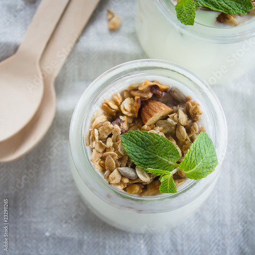 Homemade granola with greak yogurt in a glass jar. Healthy food concept. Top view, copy space photo