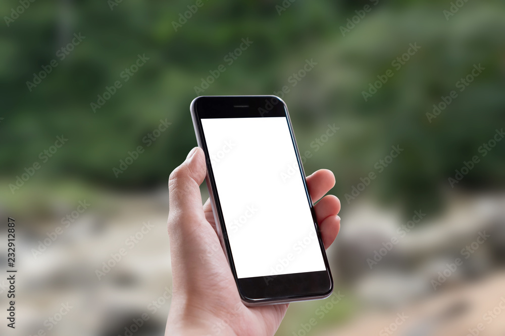Mockup smartphone blank screen in woman hands over blurred background.
