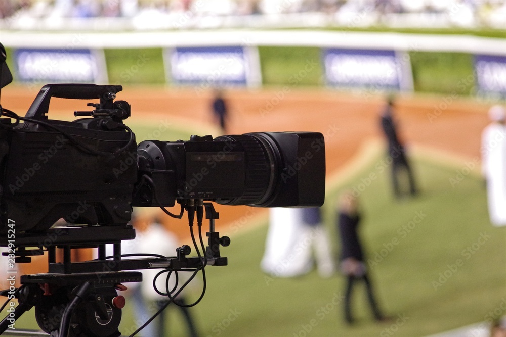 Professional digital video camera. tv camera in a sport event. Blurry background.