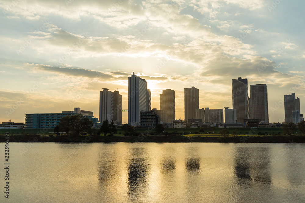 the sun sets in the buildings across the Tama River Kawasaki Kanagawa Japan