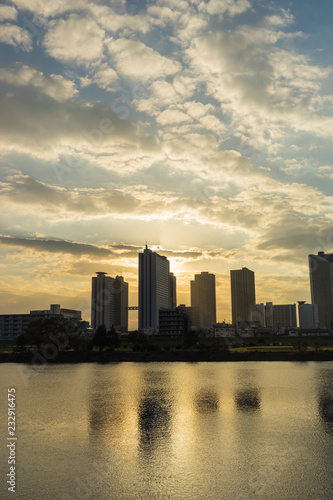 the sun sets in the buildings across the Tama River Kawasaki Kanagawa Japan © EISAKU SHIRAYAMA