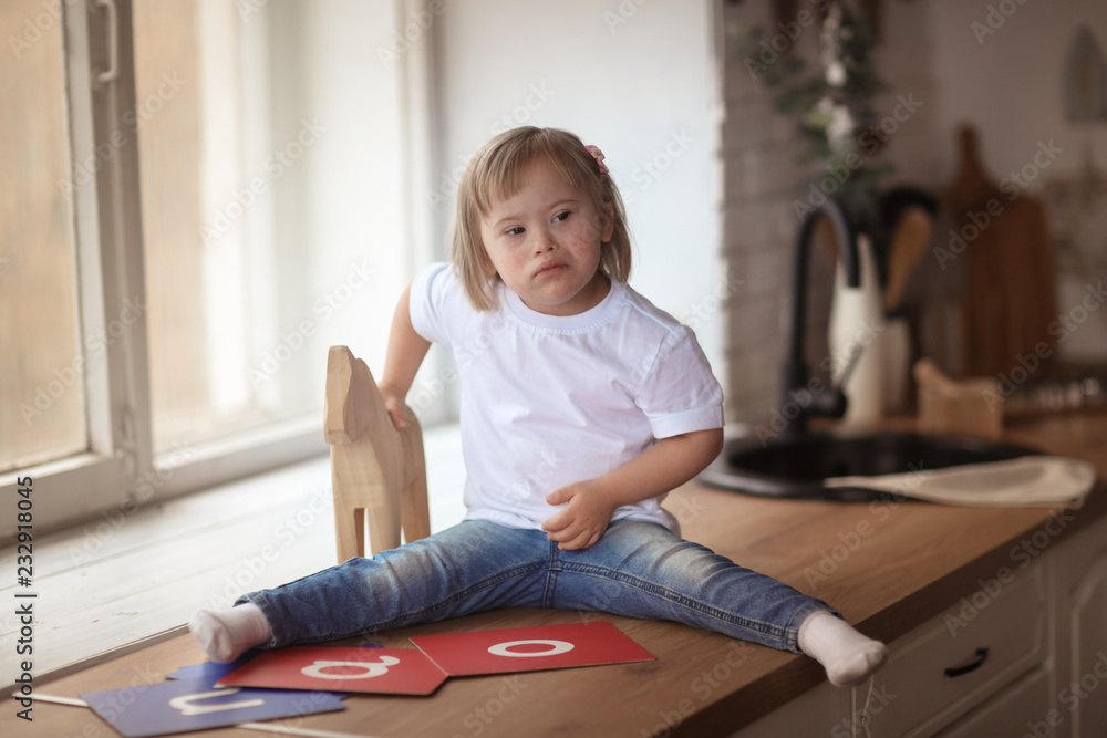 Naklejka premium baby with Down syndrome learns and plays