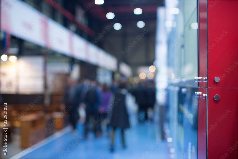 Fototapeta premium Business Convention Conference Blurred Defocused. Retail Sales Exhibition with People. Business Fair Expo Booth with People Shopping. Trade Show Building Interior Background with Exhibitors.