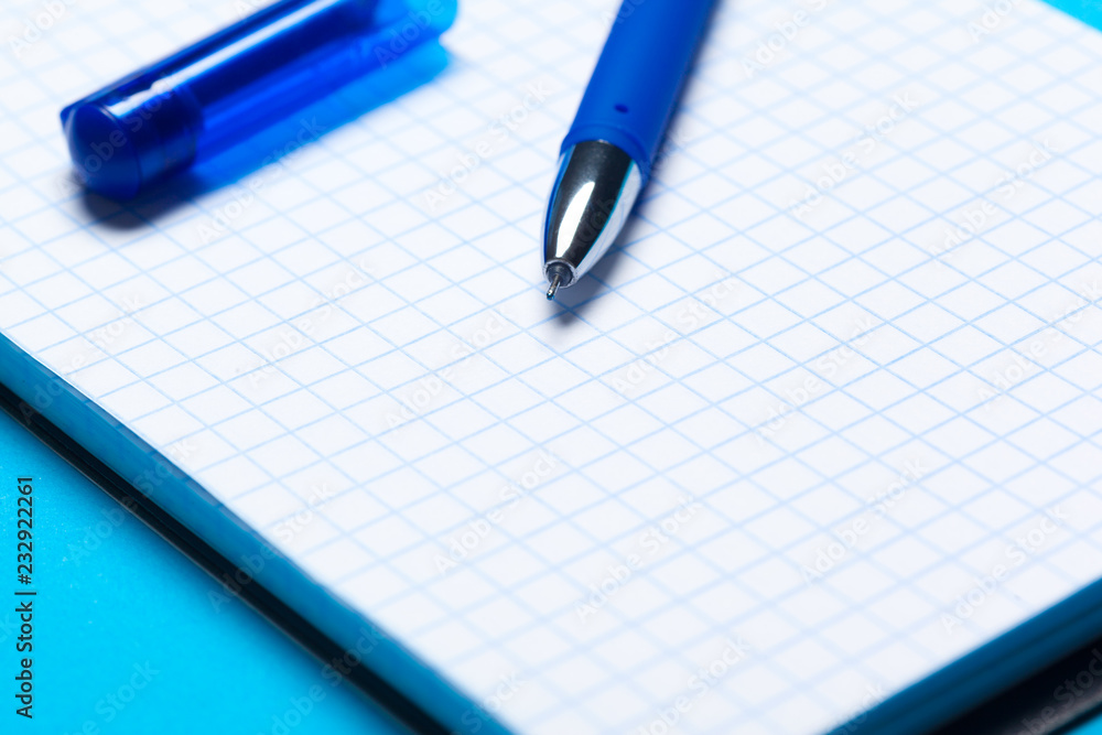 Top view workspace mockup on blue background with notebook, pen Top view workspace mockup on blue background with notebook, pen