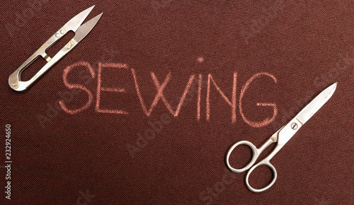 Sewing written on fabric with scissors in corners.