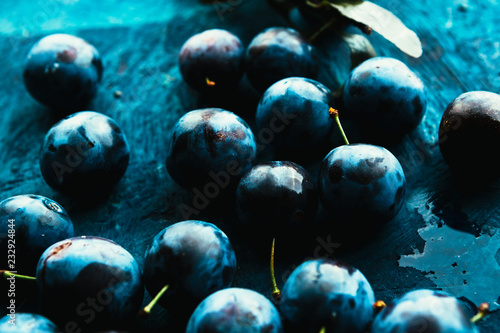 Obraz na płótnie many fresh plums on blue background close up.