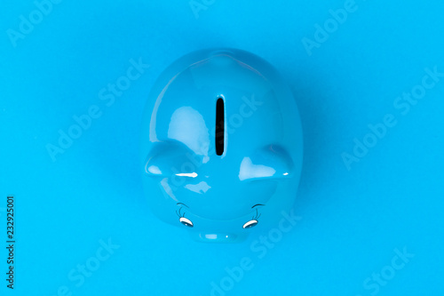 Blue piggy bank money box on bright colored background